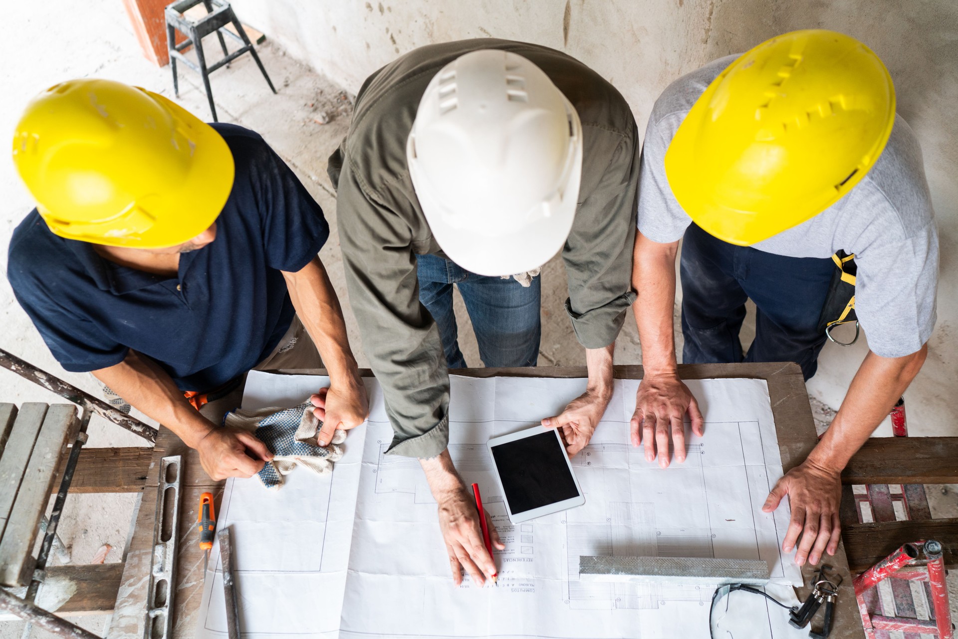 Construction Workers Collaborating Over Blueprint Onsite